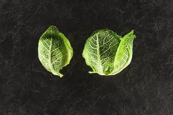 top view of fresh healthy green savoy cabbage on black  