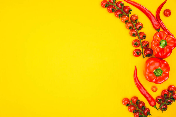 top view of fresh raw peppers and cherry tomatoes isolated on yellow 