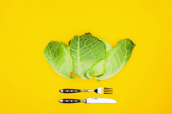 top view of fresh healthy cabbage and fork with knife isolated on yellow