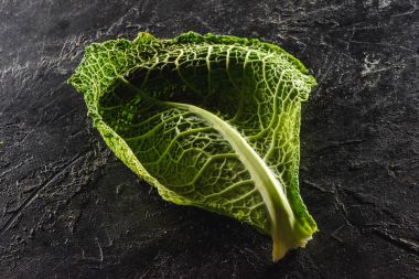 close-up view of leaf of fresh healthy savoy cabbage on black   clipart