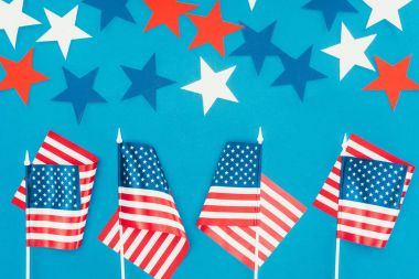 top view of arranged stars and american flags isolated on blue, presidents day celebration concept clipart