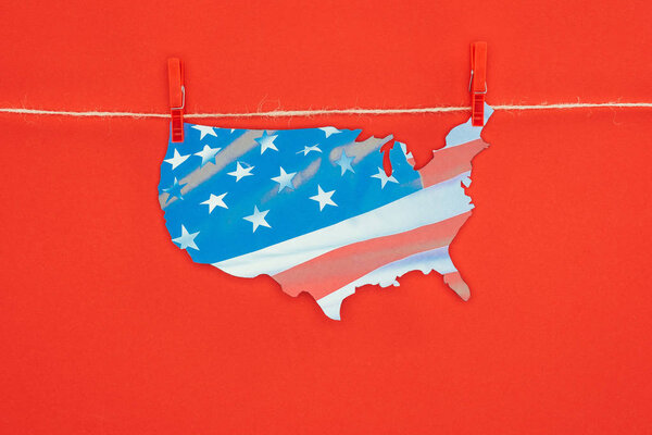 верхний вид кусок карты с американским флагом висит на веревке изолированы на красный, президентский день концепции
