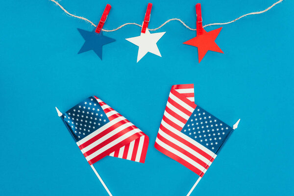 top view of arranged stars and american flags isolated on blue, presidents day celebration concept