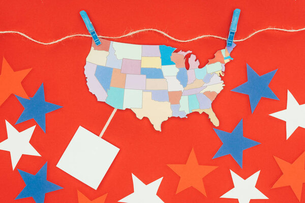 Top view of piece of map with usa states hanging on rope and stars isolated on red
