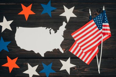 top view of arranged american flags, piece of map made of paper and stars on wooden surface, presidents day celebration concept clipart