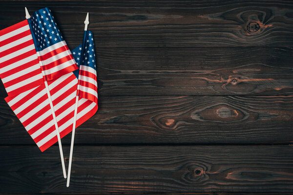 верхний вид устроенных американских флагов на темной деревянной поверхности, концепция празднования Дня президентов
