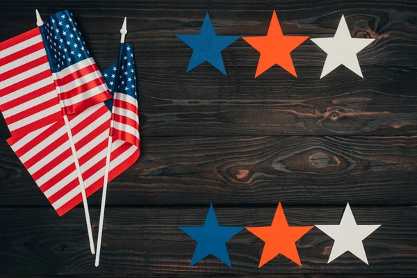 top view of arranged american flags and stars on wooden surface, presidents day celebration concept