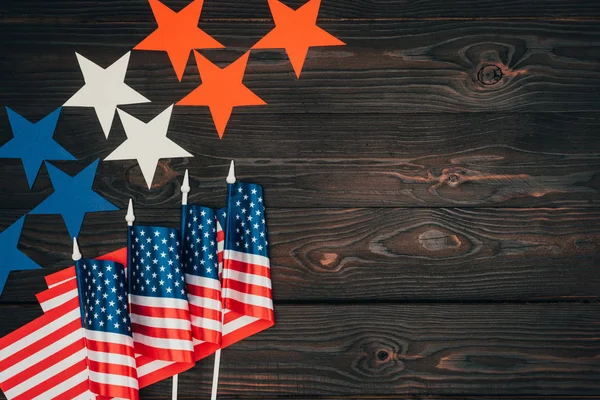 top view of arranged american flags and stars on wooden surface, presidents day celebration concept