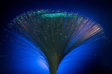 glowing fiber optics on dark blue background clipart