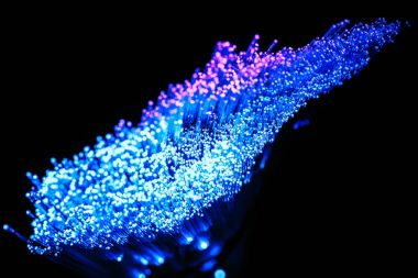 koyu arka plan üzerinde parlayan mavi ve mor fiber optik