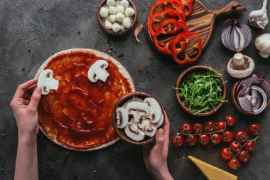mantar dilimleri üzerine pizza beton tablo üzerinde yayılan kadın görüntüsünü kırpılmış