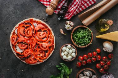 Beton tablosundaki çeşitli malzemelerle çiğ pizza Üstten Görünüm