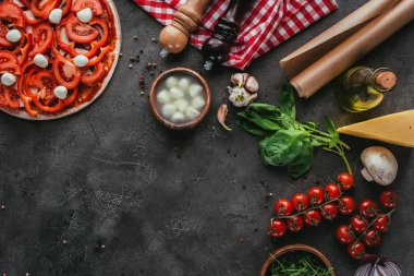 Beton masada malzemelerle çiğ pizza Üstten Görünüm