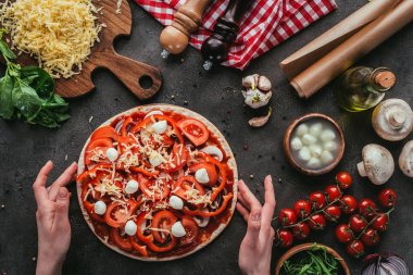 çiğ pizza beton masaya tutan kadın görüntüsünü kırpılmış