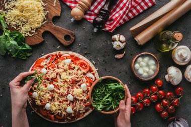 Yeşiller beton masada pizzayla kapsayan kadın görüntüsünü kırpılmış