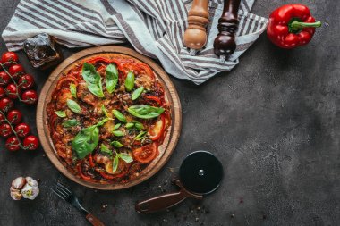 taze pişmiş pizza kesici ve malzemeler ile üstten görünüm beton masada