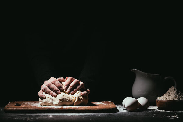 cropped shot of person preparing dough on black