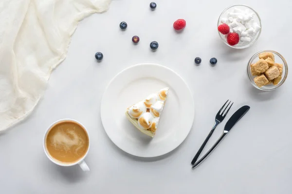 白色桌上有浆果和咖啡的美味蛋糕的顶级视图 — 图库照片
