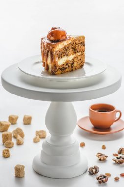 Beyaz pastayı lezzetli karamelli pasta parçası standı, kahve masada