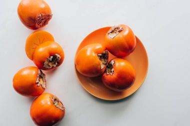 Üstten Görünüm persimmons turuncu plaka ve beyaz masa üstü