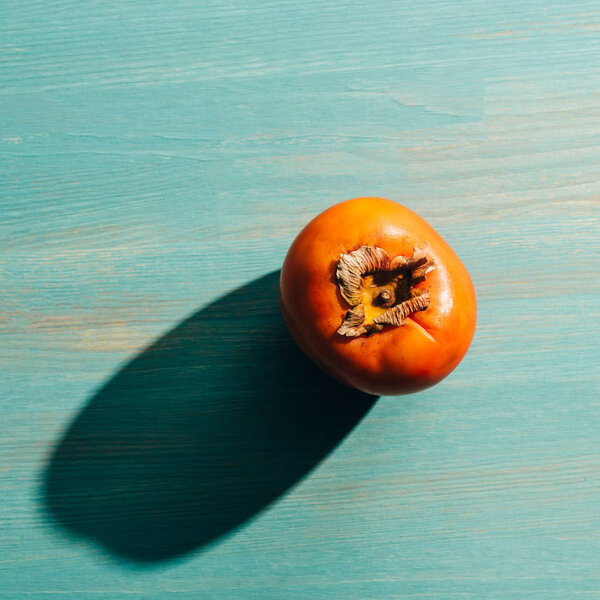 top view of persimmon ripe persimmon on wooden table with light and shadow
