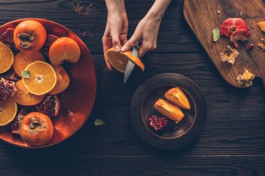 cropped image of woman peeling orange clipart