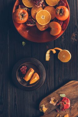 portakal ve nar ile kesme persimmons üstten görünüm plakaları