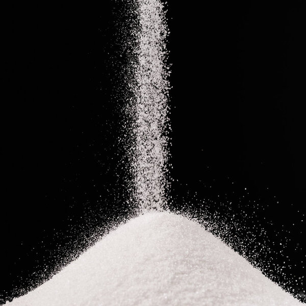 sugar falling on pile isolated on black