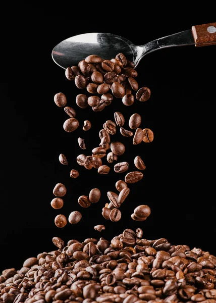 Kaffebönor Som Faller Från Spoon Högen Isolerade Svart — Stockfoto