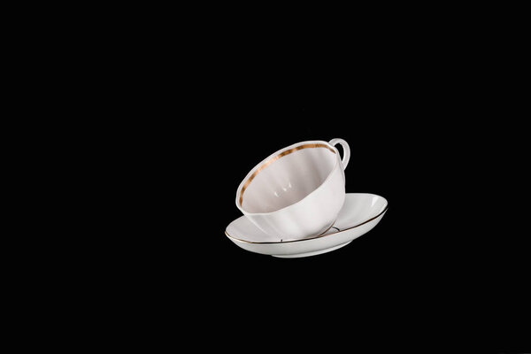 white cup and plate isolated on black