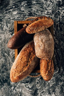 üst düzenlenmiş ekmek unu ile karanlık masa üstü ahşap kutusunda loafs