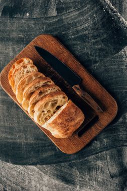 Un ile karanlık yüzeyinde bıçak ile kesme tahtası üzerinde görücü usulü adet ciabatta Üstten Görünüm