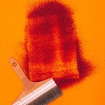 Top view of red sand for decoration and brush isolated on orange