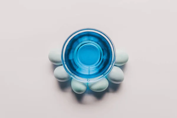 Vista Superior Vidro Com Tinta Azul Ovos Galinha Superfície Branca — Fotos gratuitas