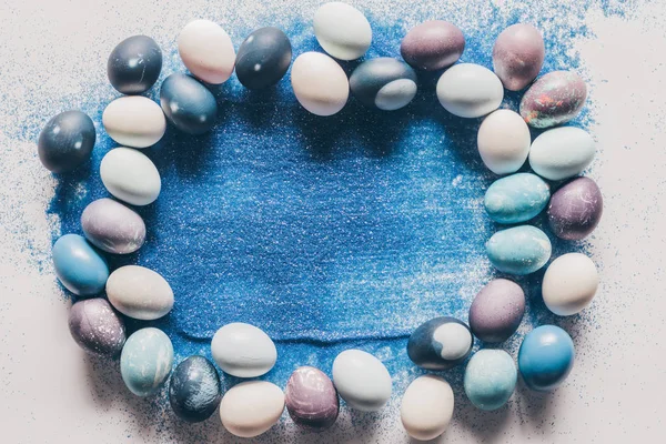 Ansicht Von Bemalten Ostereiern Und Blauem Sand Auf Weißer Oberfläche — Stockfoto