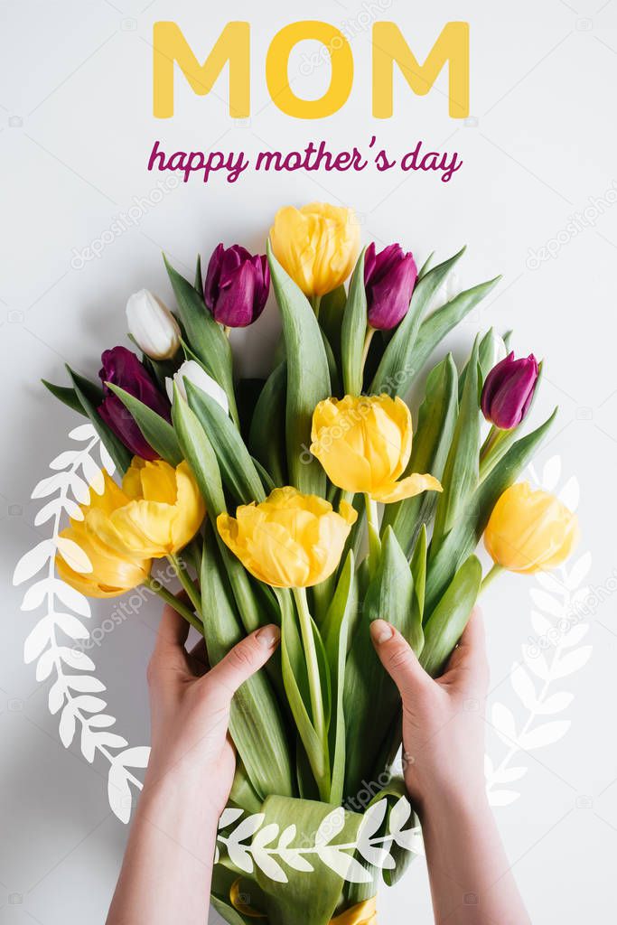 cropped view of hands with bouquet of spring tulips with HAPPY MOTHERS DAY inscription