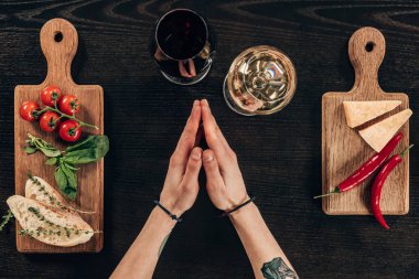 şarap ve parmesan peyniri ile masada oturan kadının kırpılmış görüntü