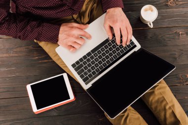 Boş ekran, dijital tablet ve yanında kahve fincanı ile laptop yazdırma iş adamı