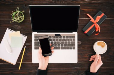 Bussinesswoman smartphone, kahve fincanı, laptop ve hediye kutusu ile kırpılmış görüntü