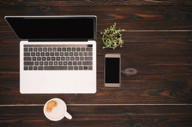 Boş ekran, kahve fincanı, smartphone ve saksı bitki ile dizüstü Üstten Görünüm
