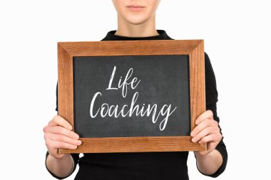 Cropped view of woman holding board with lettering life couching isolated on white clipart
