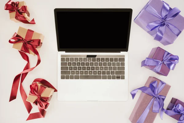 Draufsicht Auf Laptop Mit Leerem Bildschirm Zwischen Geschenkboxen — kostenloses Stockfoto