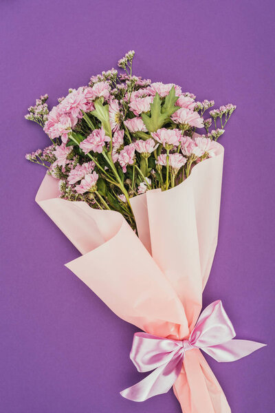 beautiful floral bouquet with pink ribbon on violet 