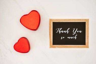 top view of blackboard in frame with THANK YOU SO MUCH lettering with heart shaped isolated on white clipart