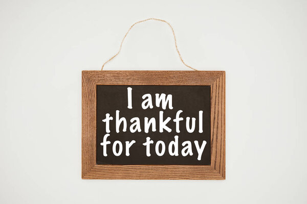 i am thankful today lettering on chalkboard with wooden frame and thread isolated on white