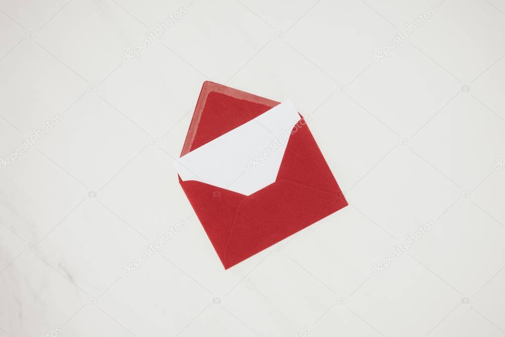 top view of opened red envelope with blank paper isolated on white