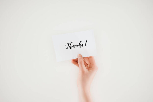 cropped shot of woman holding paper with thanks lettering isolated on white