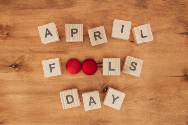 top view of arranged wooden cubes in april fools day lettering on wooden tabletop, 1 april holiday concept clipart