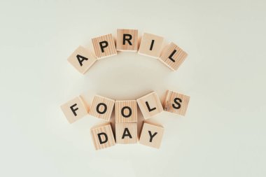 top view of arranged wooden cubes in april fools day lettering isolated on grey tabletop, 1 april holiday concept clipart
