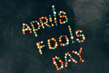 top view of arranged candies in aprils fools day lettering isolated on black tabletop clipart